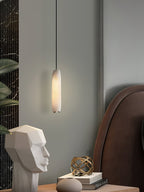 Clérachic pairs the Asbury with a brown leather headboard, its glow falling on a white stone face sculpture and books.