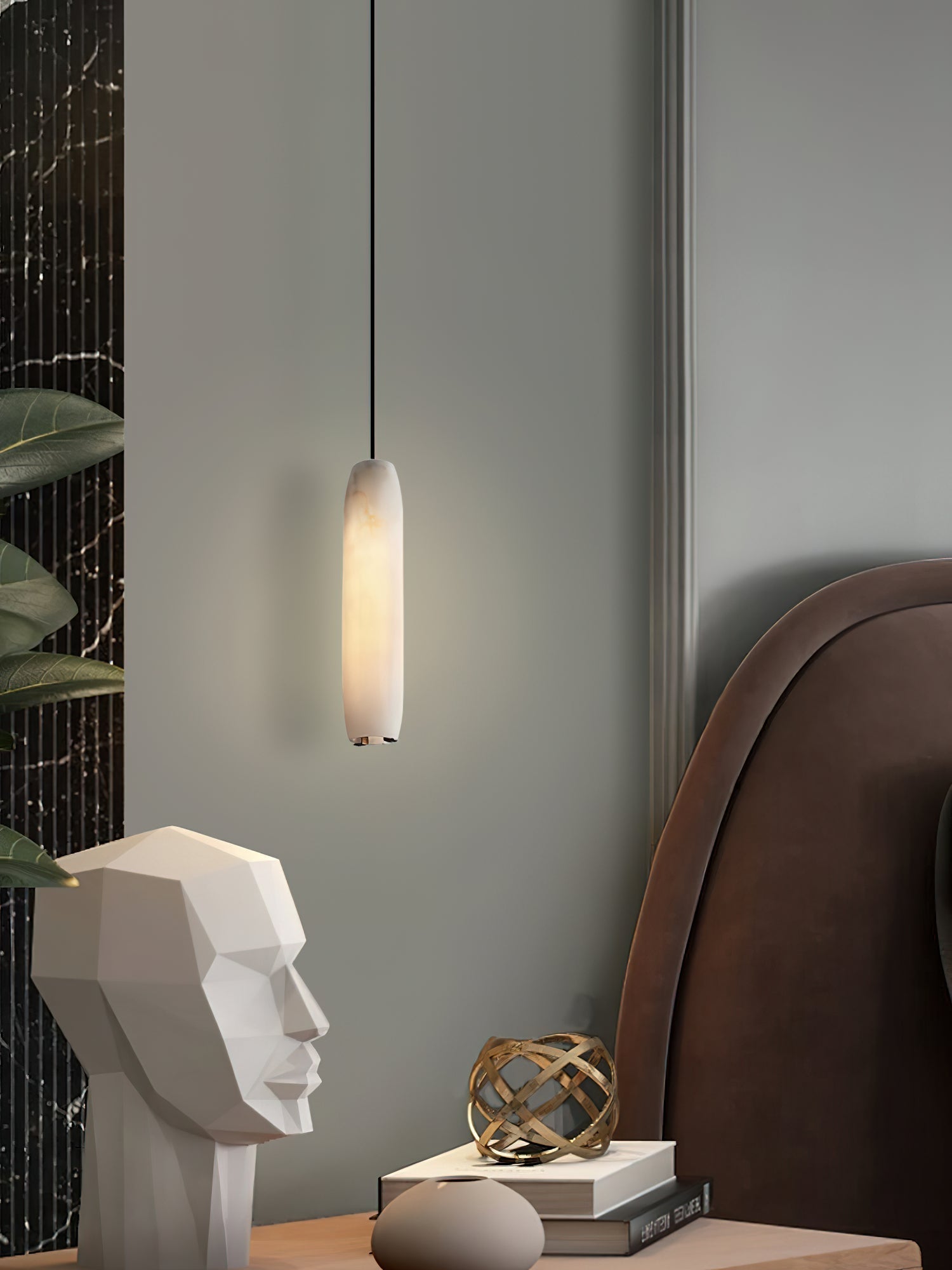 Clérachic pairs the Asbury with a brown leather headboard, its glow falling on a white stone face sculpture and books.