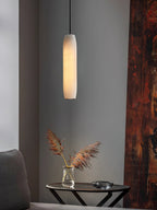 The Clérachic Asbury lights a corner of weathered rust-red timber, above a round table holding dried pampas grass.