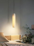 Clérachic warms a dark bedroom wall with the Asbury pendant, spilling light over an open book and trailing greenery.
