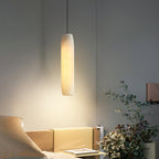 The Clérachic Asbury throws a soft pool of light across an oak bed and a pot of dried hydrangea in a dim bedroom.