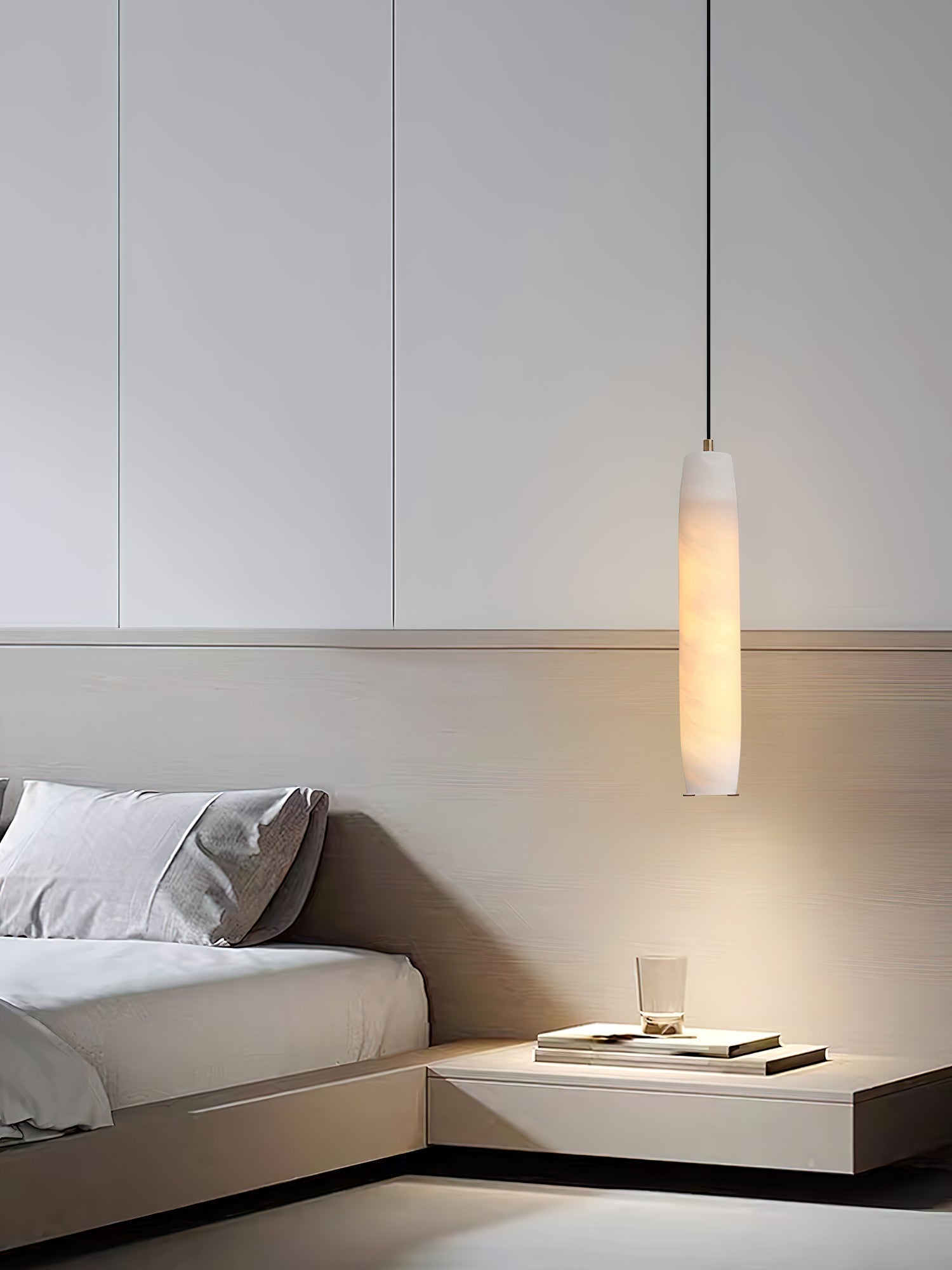 Clérachic drops the Asbury over a built-in bedside ledge, its warm light washing the pale wood headboard behind.