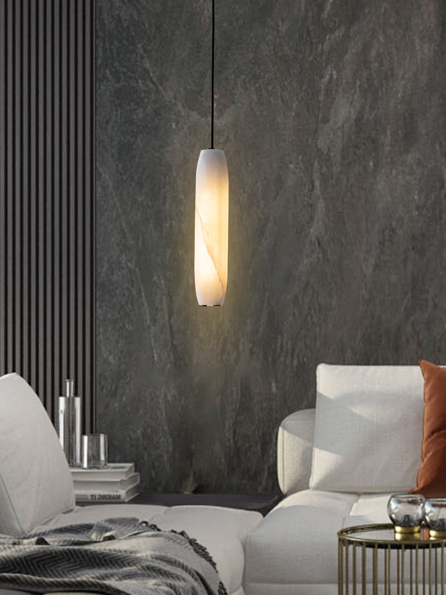 Clérachic sets the Asbury against a dark slate wall, its warm glow reaching a white armchair and brass side table.