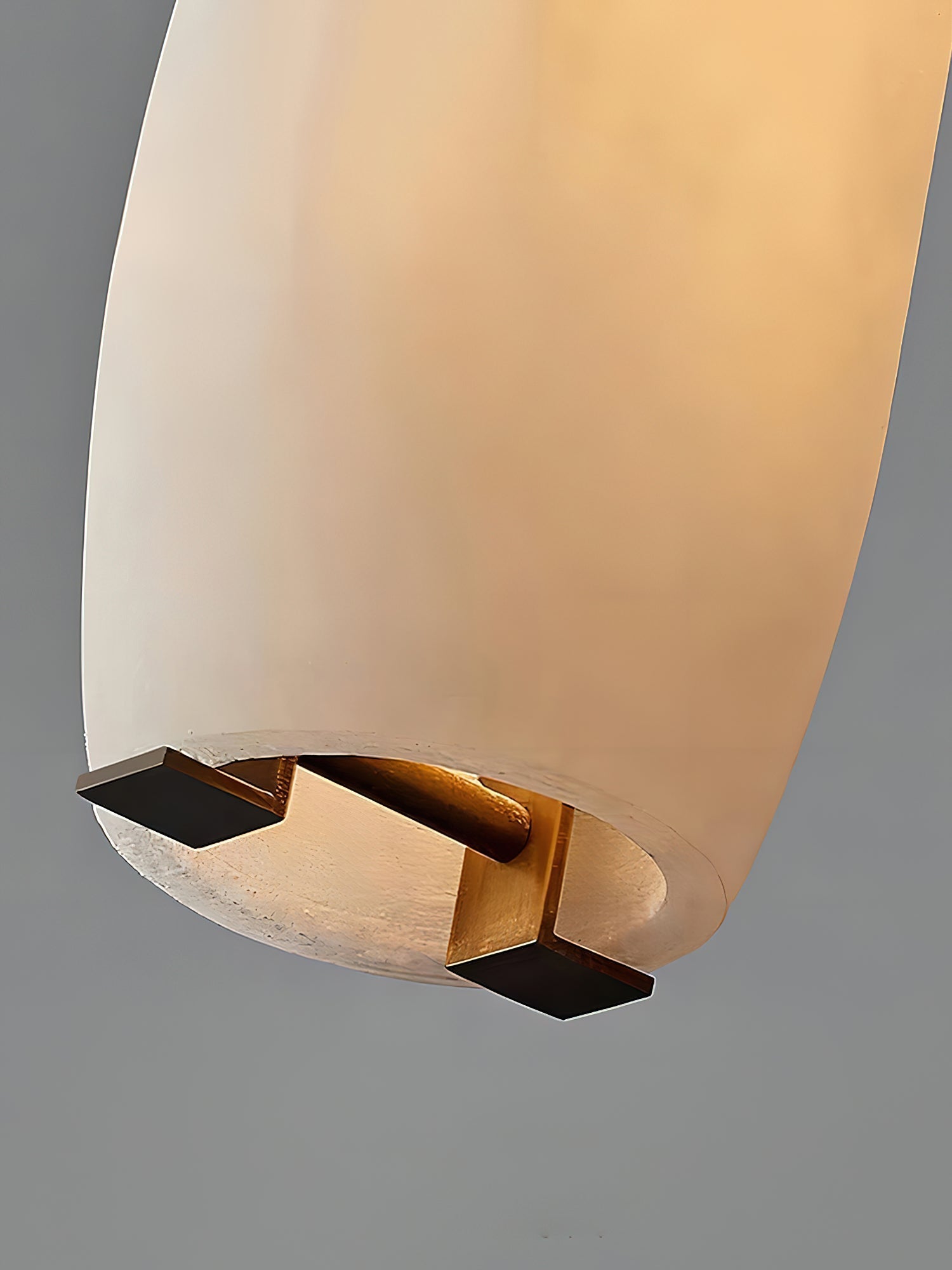 Clérachic looks up into the open base of the Asbury shade, where a brass cross fitting holds the lit alabaster tube.