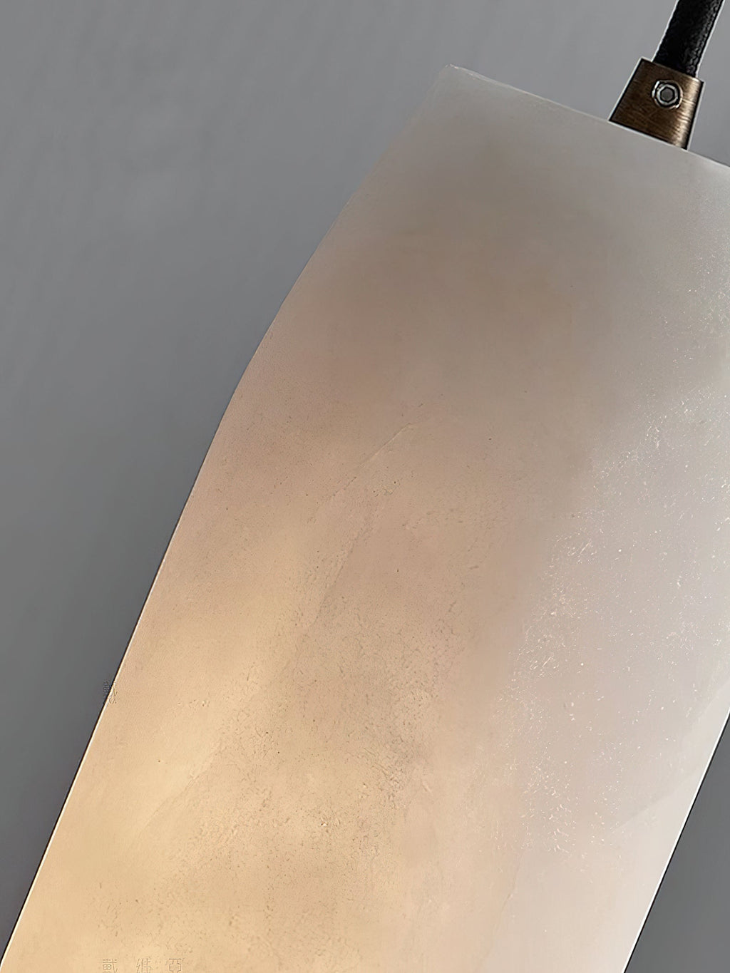 The Clérachic Asbury shade in extreme close-up, warm light revealing the fine crystalline texture of the alabaster.