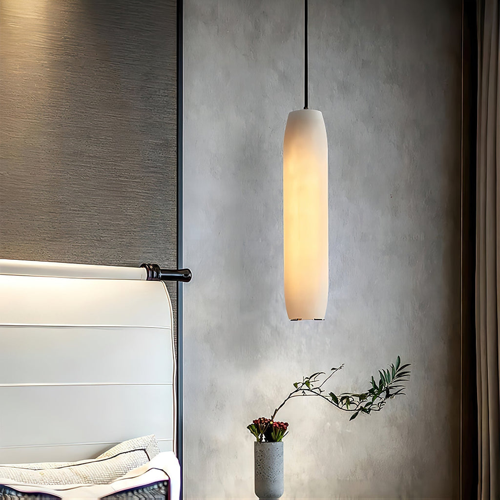 The Clérachic Asbury seen from the foot of the bed, its lit shade set against grey plaster and a black wall bracket.