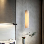 The Clérachic Asbury seen from the foot of the bed, its lit shade set against grey plaster and a black wall bracket.