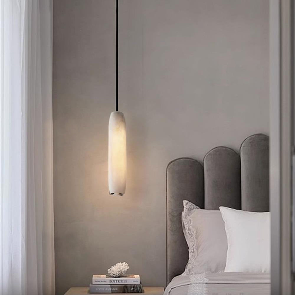Clérachic hangs the Asbury beside a scalloped grey headboard, lighting a nightstand stacked with books and coral.