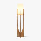 Tall ash wood frame with a curved cut-out and a white fabric shade, this Clérachic floor lamp shown lit on a plain white backdrop.