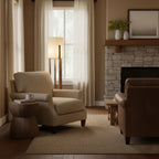 Slim wooden floor lamp from Clérachic glowing by a window with cream curtains, above a woven rug and a beige armchair.