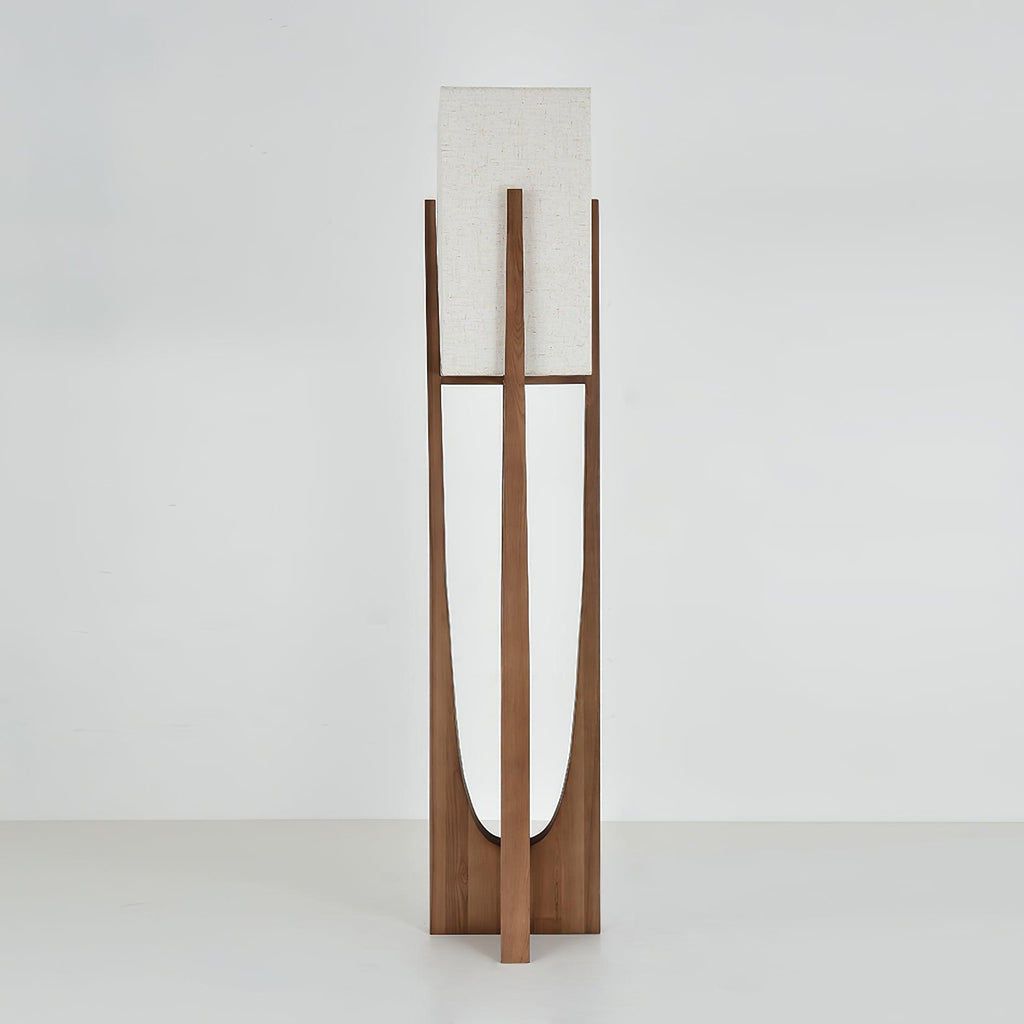 Dark wood floor lamp from Clérachic with an unlit fabric shade, on a pale grey backdrop, with the curved cut-out showing.