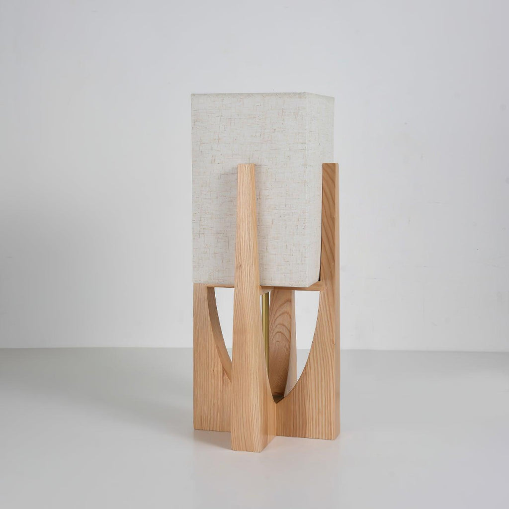 Short Clérachic table lamp in natural wood, its fabric shade close to the frame, shown on a grey backdrop.