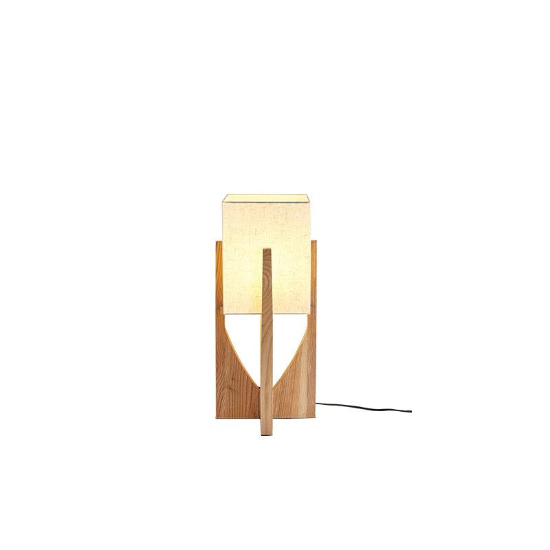 Short natural wood Clérachic lamp with an unlit fabric shade and a black cord, on a white backdrop.