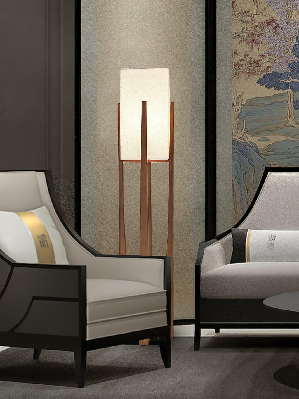 Lit Clérachic floor lamp between two grey-and-black armchairs, in front of a painted landscape panel.
