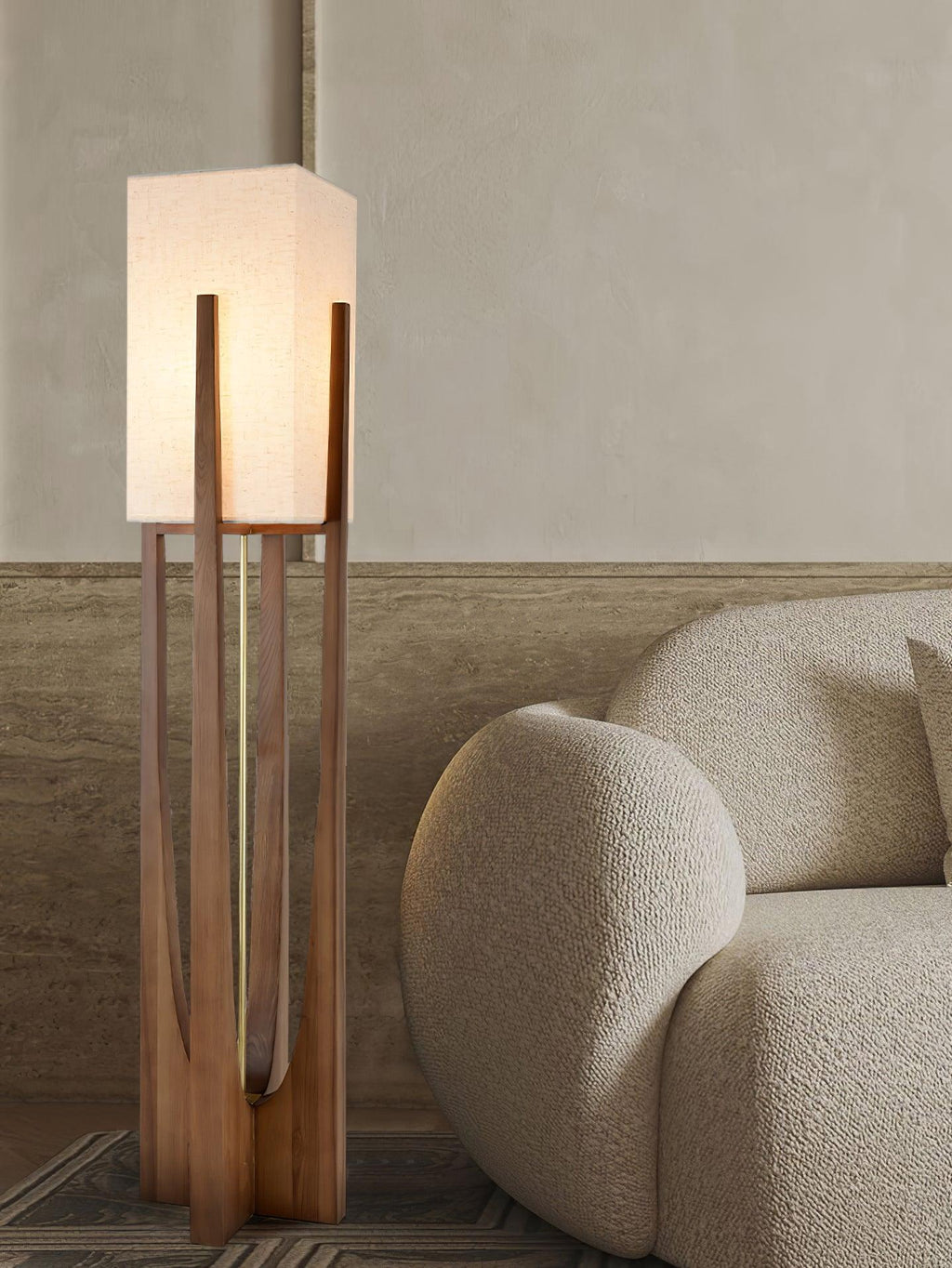 Close view of the lit fabric shade and wooden frame on this Clérachic floor lamp, beside a boucle armchair.