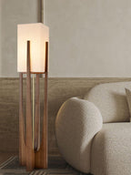 Close view of the lit fabric shade and wooden frame on this Clérachic floor lamp, beside a boucle armchair.