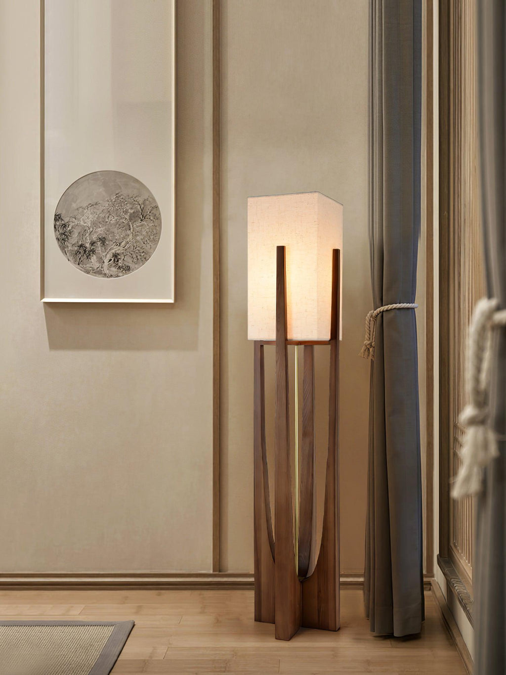 Clérachic floor lamp lit beside a window with grey curtains, in front of a framed round artwork on a cream wall.