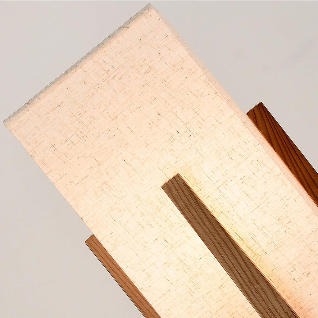 Close view of the lit fabric shade with a wooden upright in front, showing the weave of the linen on this Clérachic lamp.
