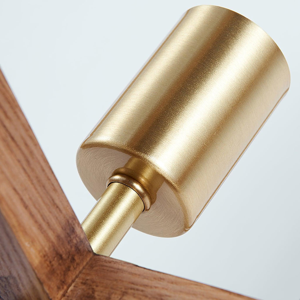 Close view of the brass bulb holder and its short stem, with the wooden frame angled behind it, on this Clérachic lamp.