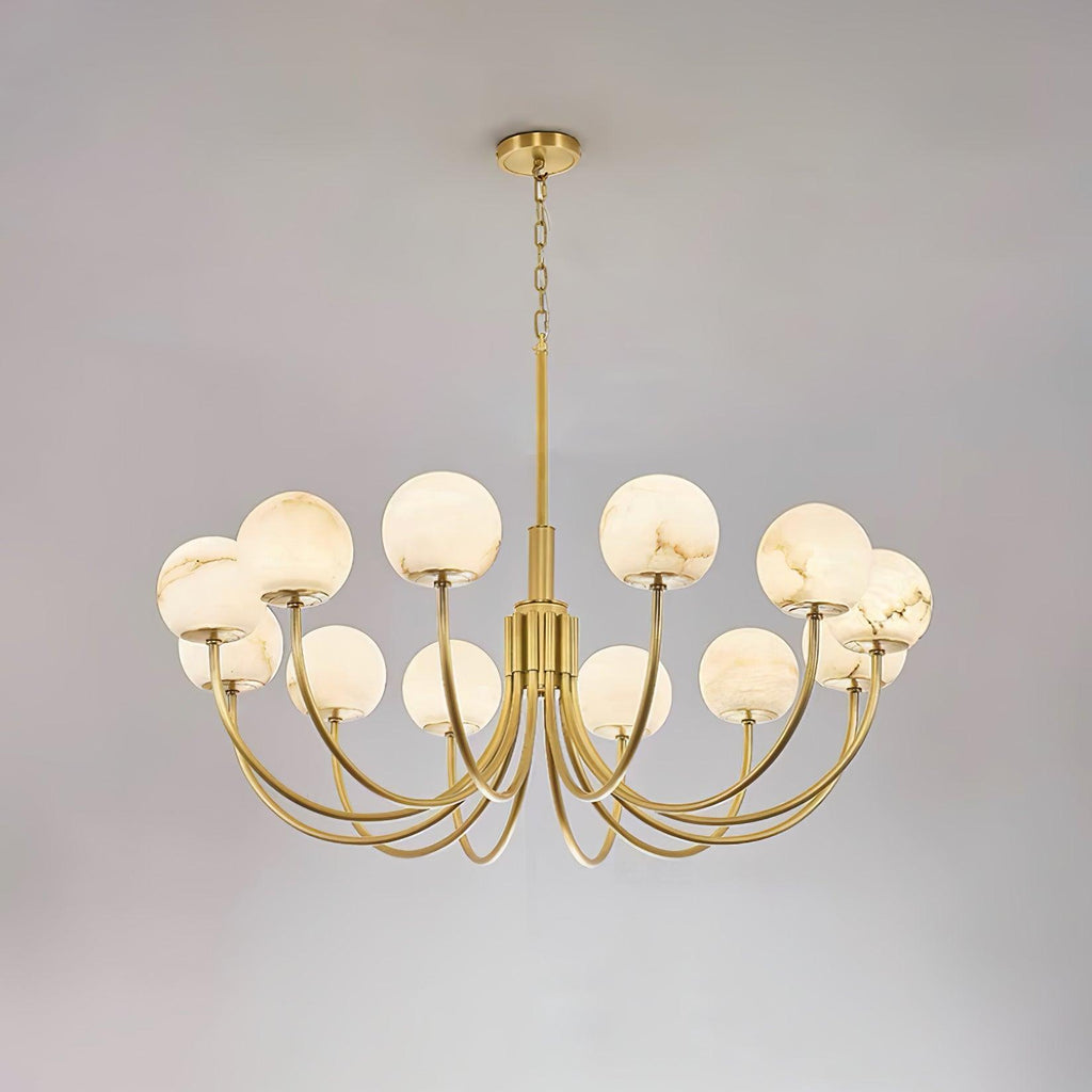 The twelve-light Clérachic Aurelian chandelier on grey, its brass arms sweeping widely outward.