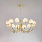 The twelve-light Clérachic Aurelian chandelier on grey, its brass arms sweeping widely outward.