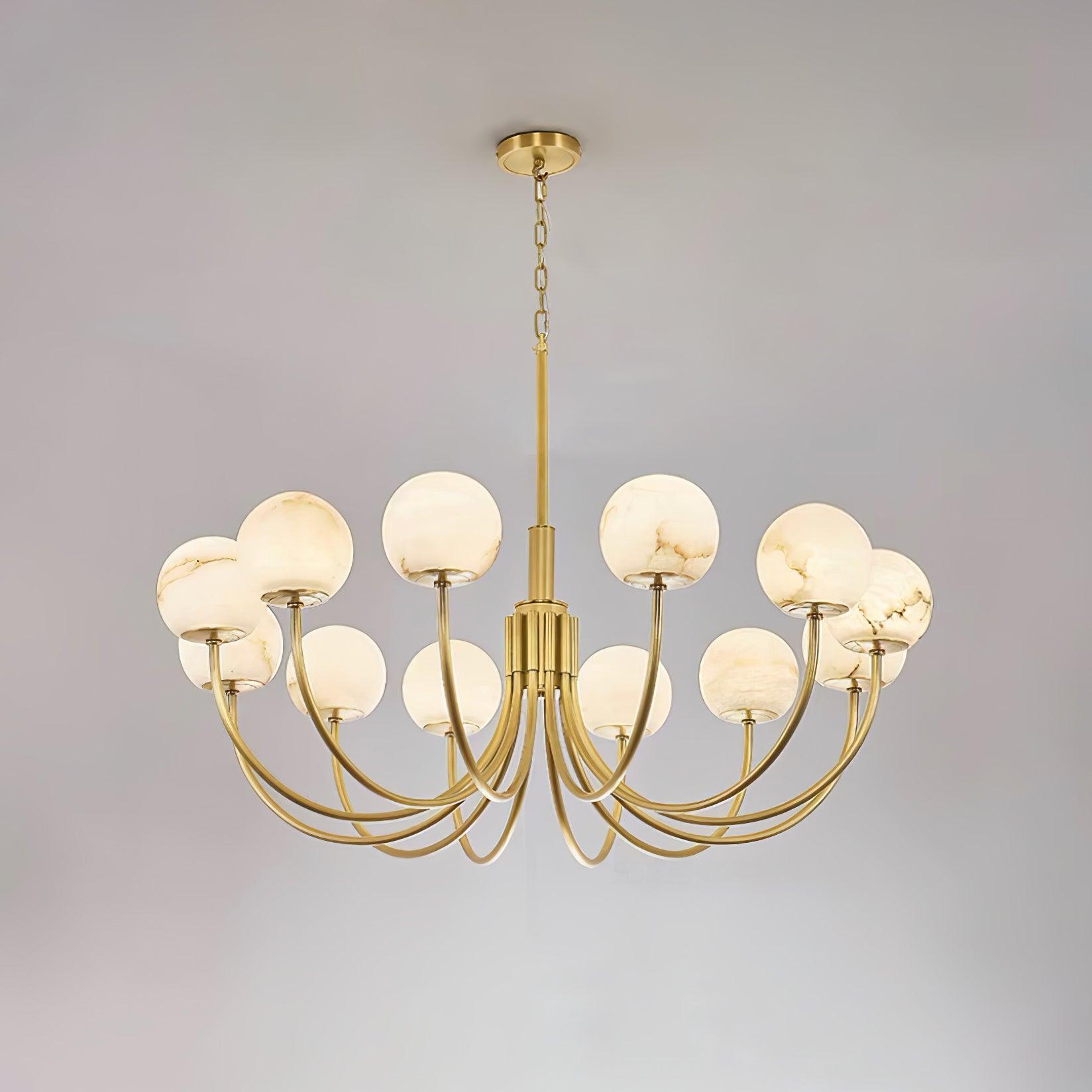 The twelve-light Clérachic Aurelian chandelier on grey, its brass arms sweeping widely outward.