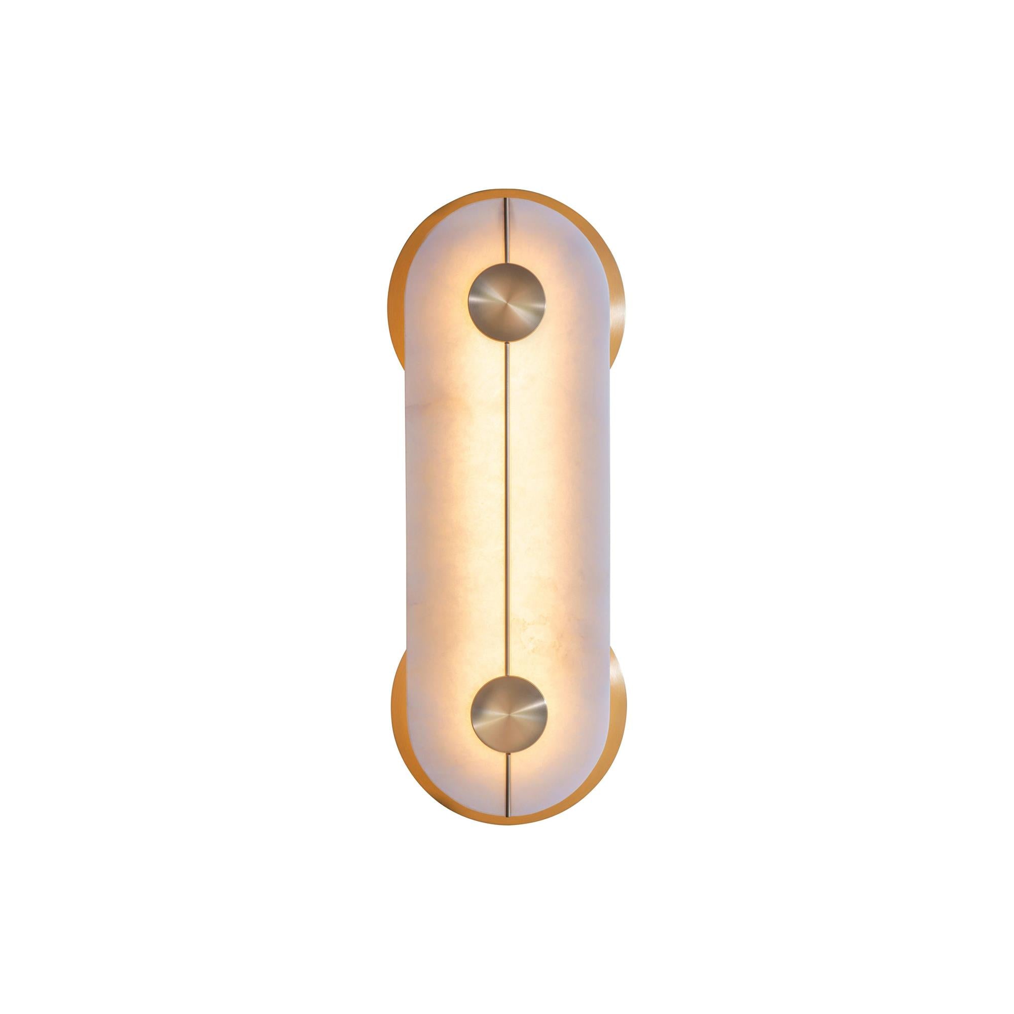 Clérachic Auriel photographed lit on plain white, the alabaster glowing warm amber between its polished brass crescents.
