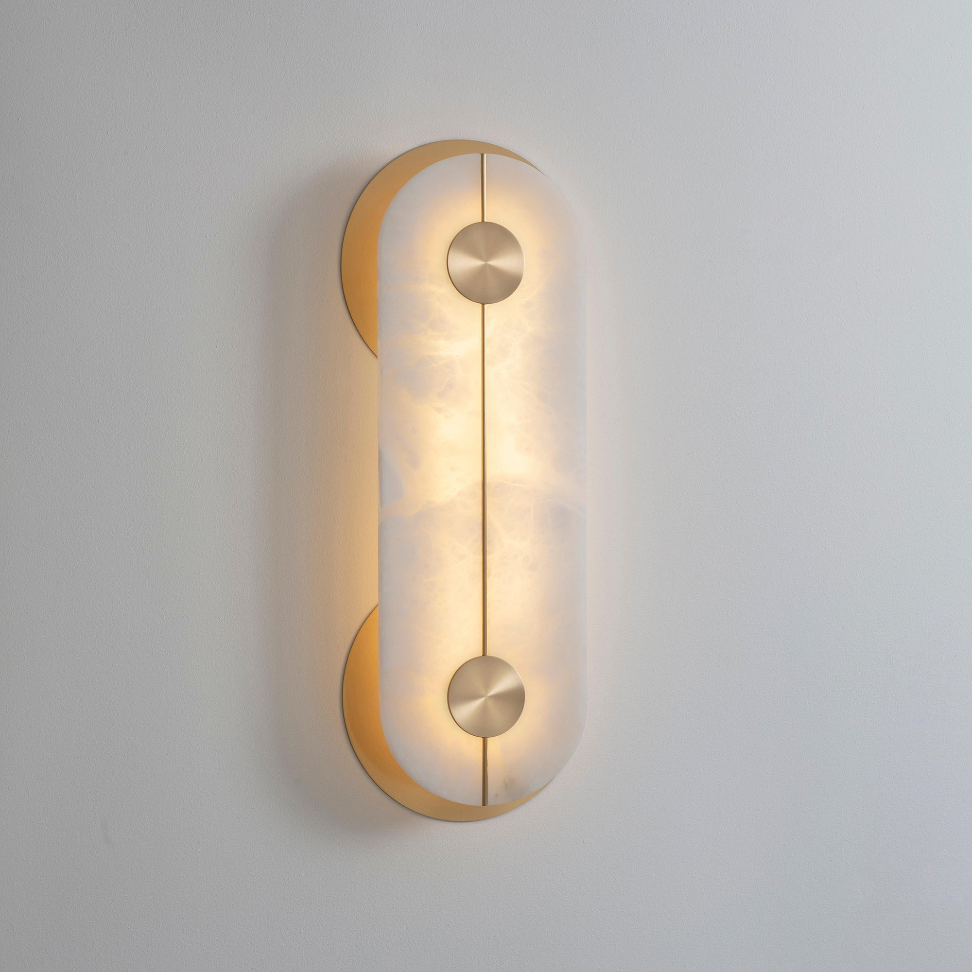 Clérachic Auriel switched on in a pale room, its integrated LED washing the alabaster with a soft honey glow.