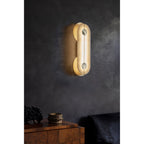 Clérachic Auriel lighting a dark plaster wall above a walnut sideboard, its warm capsule of alabaster anchoring the corner.