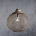 The Clérachic mesh pendant glows warmly, its rust-toned cage catching the light.