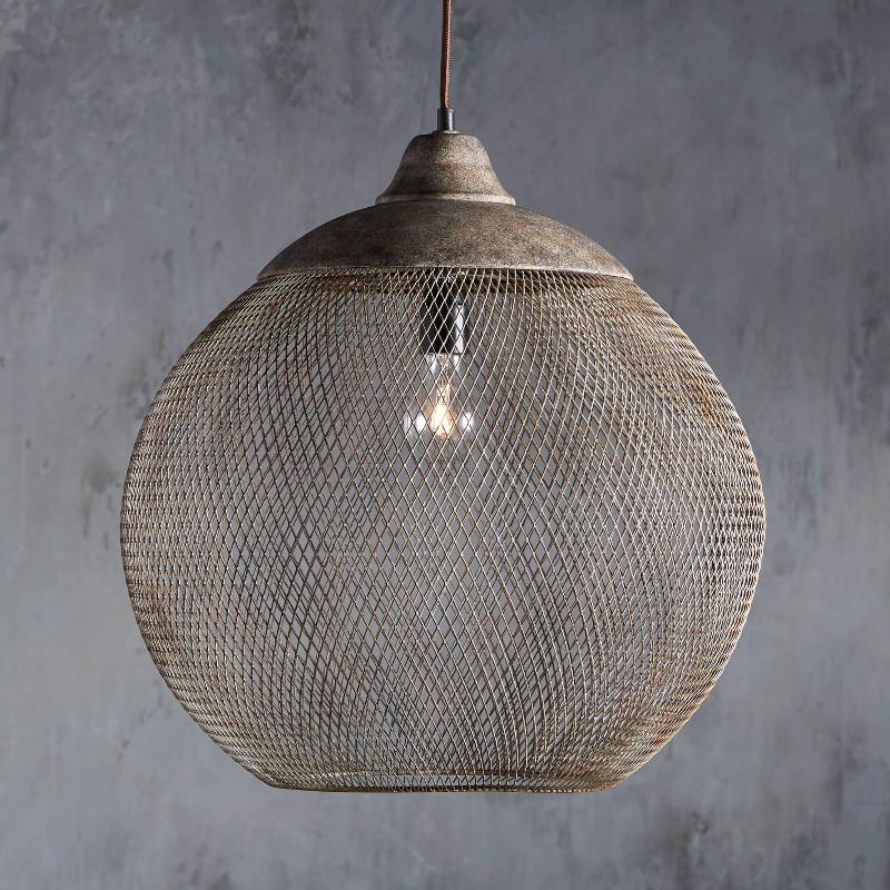 This Clérachic rust mesh pendant hangs from a dark cord against a mottled gray backdrop.