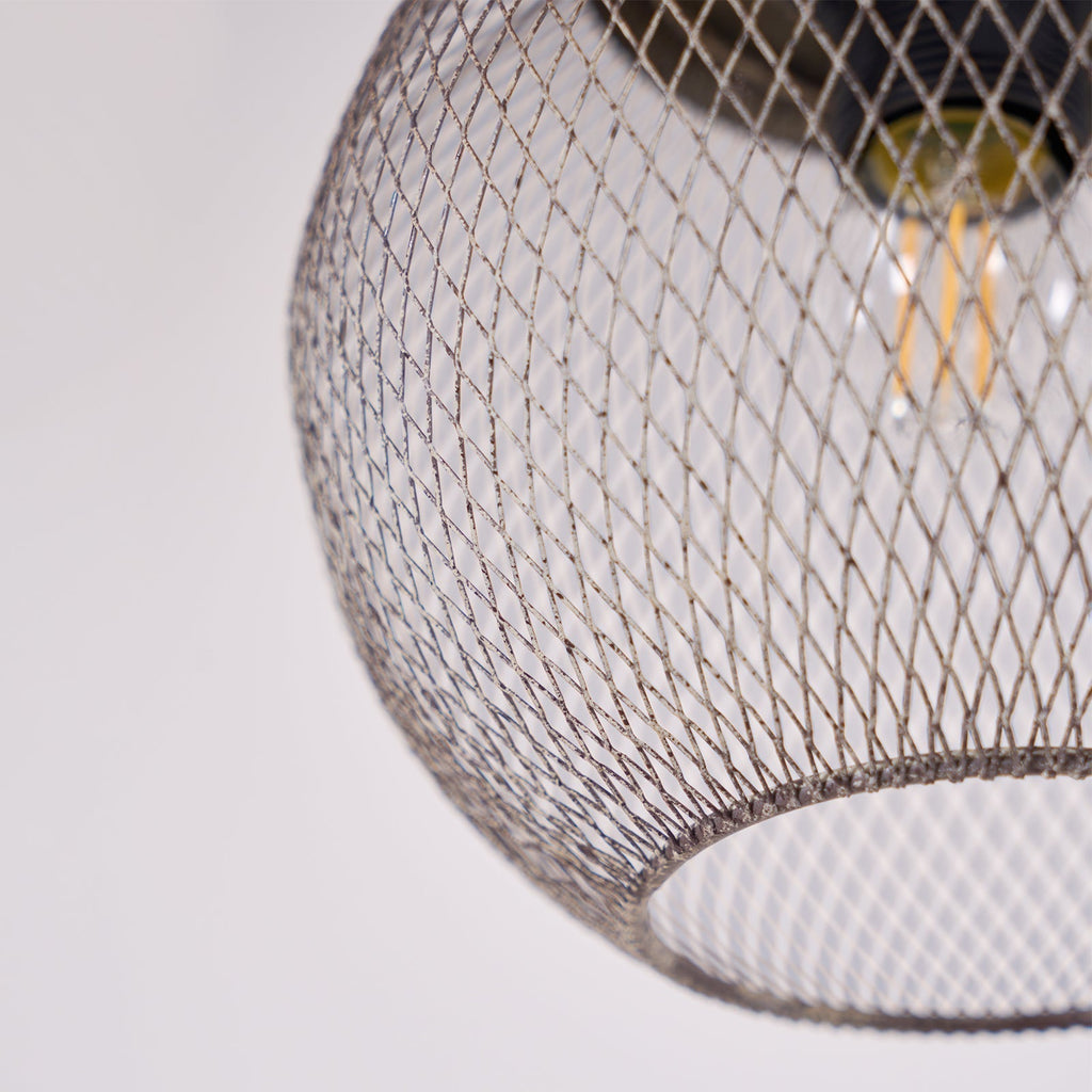 A close-up reveals the Clérachic mesh cage's fine diamond weave around a glowing bulb.