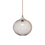 A Clérachic mesh pendant hangs on its cord, glowing softly against a plain backdrop.