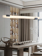 The Clérachic Avert lights a long tea table, its lit bar echoing the pale ceramics on the shelving behind.