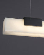 The Clérachic Avert seen end on, the lit alabaster bar glowing warm beside its blackened brass block mount.