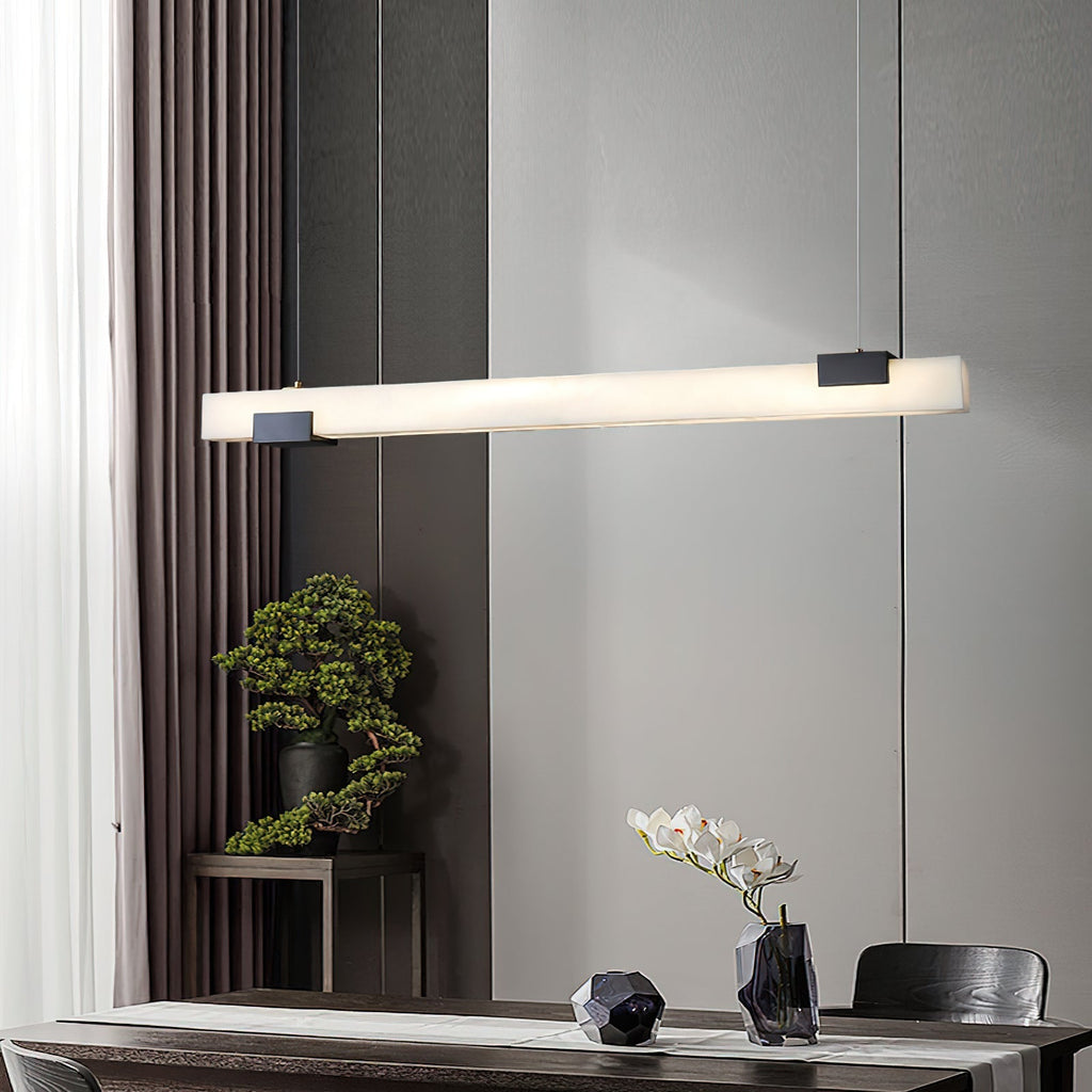 Clérachic Avert stretched above a dining table, the fluted wall and bonsai lit by its long, glare-free bar.