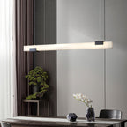 Clérachic Avert stretched above a dining table, the fluted wall and bonsai lit by its long, glare-free bar.