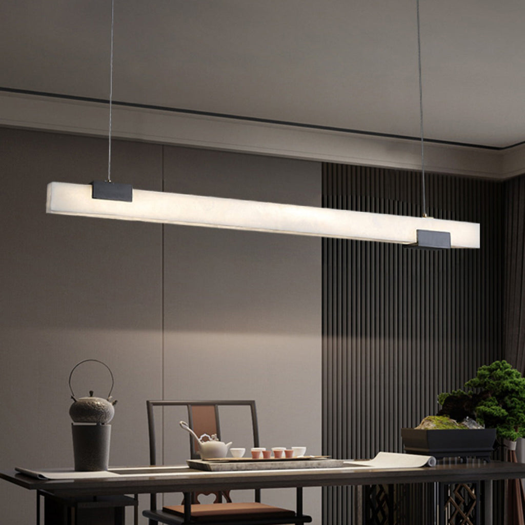 The Clérachic Avert angled over a low tea table, its alabaster bar bright against a ribbed grey wall panel.