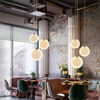 Six Clérachic alabaster discs lit above pink banquette seating in a room of exposed ducts and raw concrete.