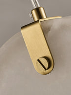 Detail of the folded brass strap and slotted pin that holds a Clérachic alabaster disc on its cable.