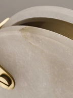 Detail of the seam on a Clérachic alabaster pendant, where the brass ring sits between the two stone faces.