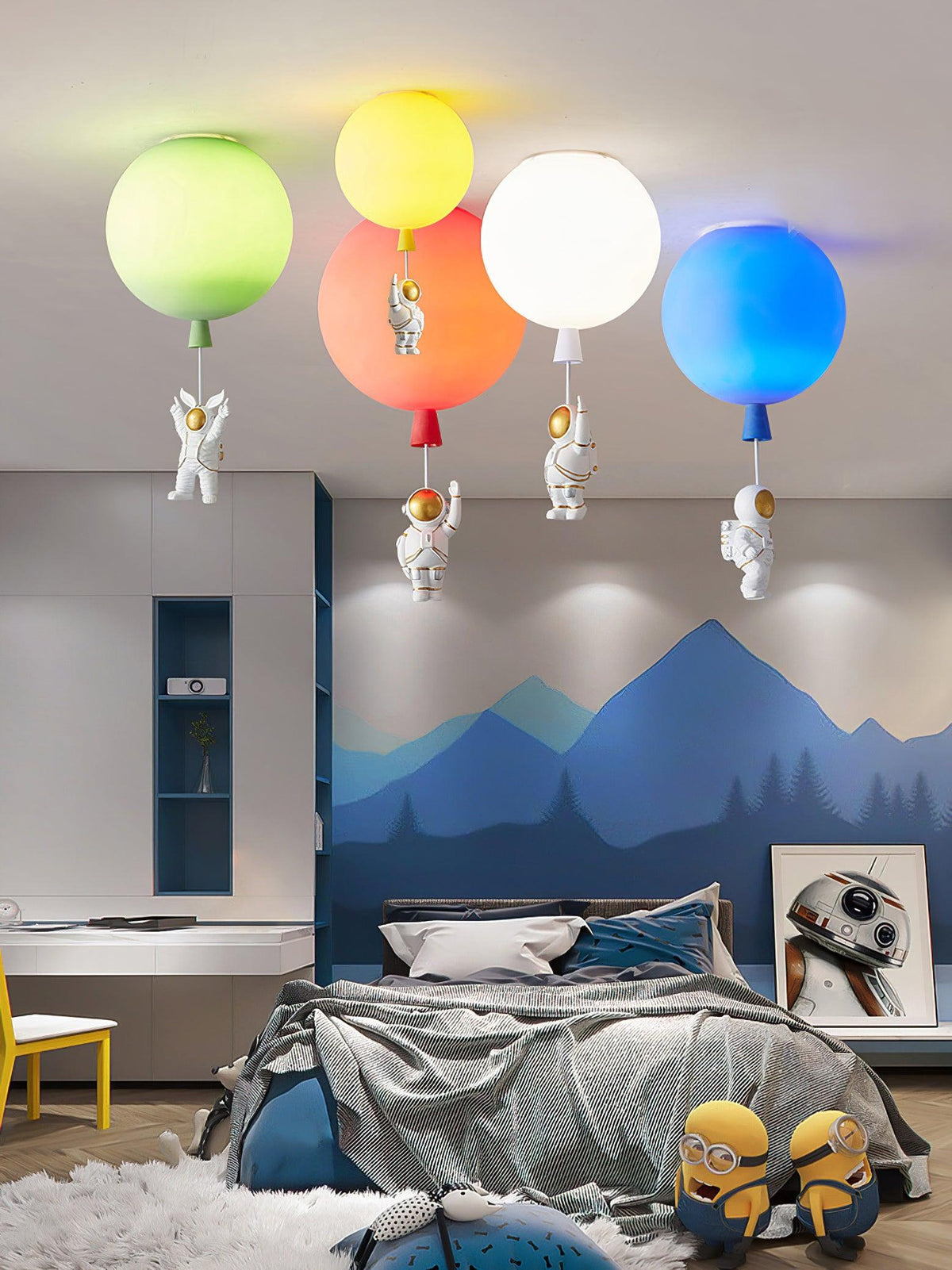 Green, yellow, orange, white and blue Clérachic balloon lights above a bed in a room painted with blue mountains.