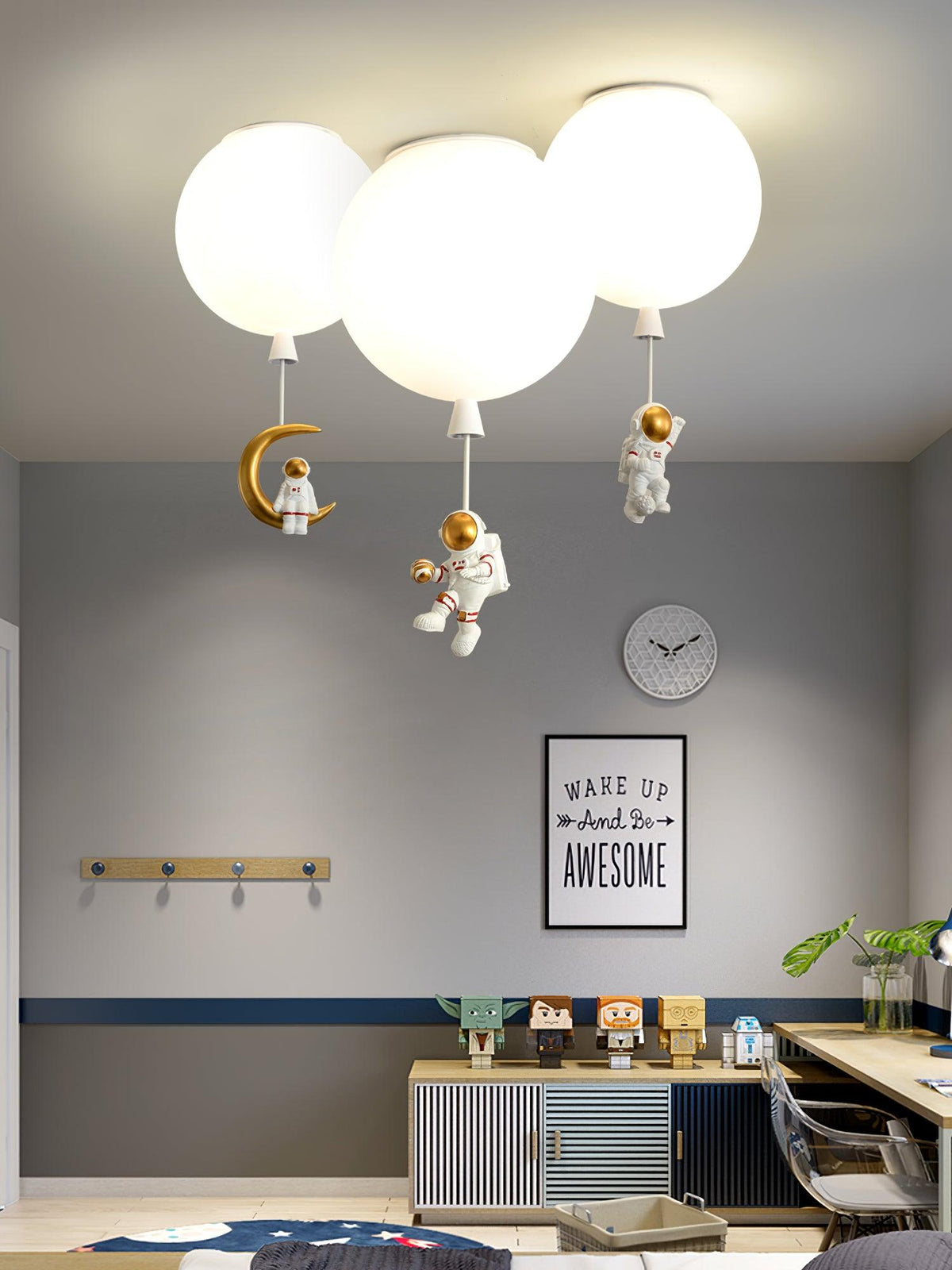 Three white Clérachic balloon lights with astronauts and a crescent moon above a grey room with a desk and a wall clock.