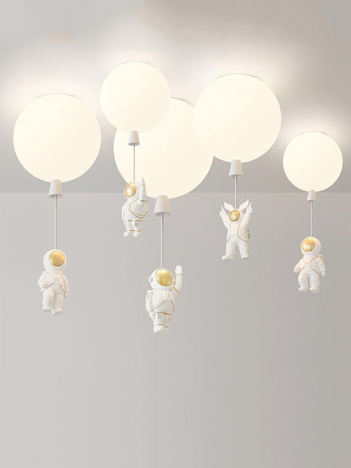 Five white Clérachic balloon lights with astronauts at different heights, shown against a plain pale backdrop.
