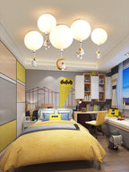Five white Clérachic balloon lights with astronauts and a moon above a yellow-themed bedroom with a built-in desk.