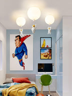 Three white Clérachic balloon lights with astronauts above a pale blue room with a bold poster and a green desk chair.