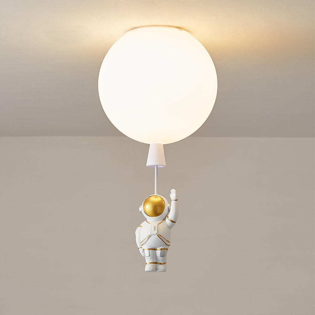 Lit white Clérachic balloon ceiling light with a glowing diffuser and a waving astronaut on a short cord.