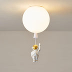 Lit white Clérachic balloon ceiling light with a glowing diffuser and a waving astronaut on a short cord.