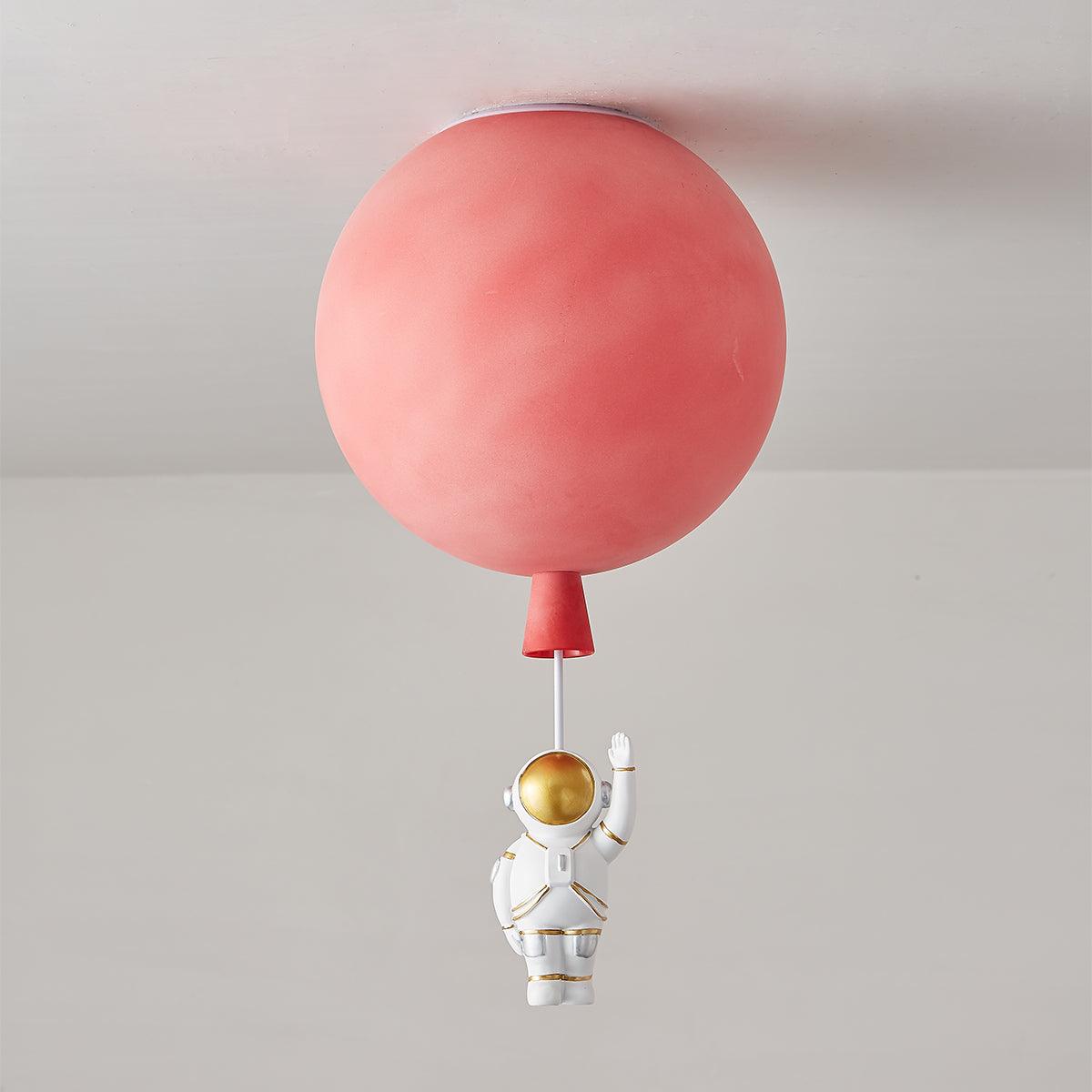 Red Clérachic balloon ceiling light, unlit, with a red cap and a waving astronaut hanging below it.