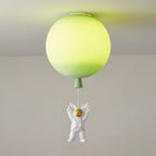 Lit green Clérachic balloon ceiling light with a lime glow and an astronaut with raised arms beneath it.